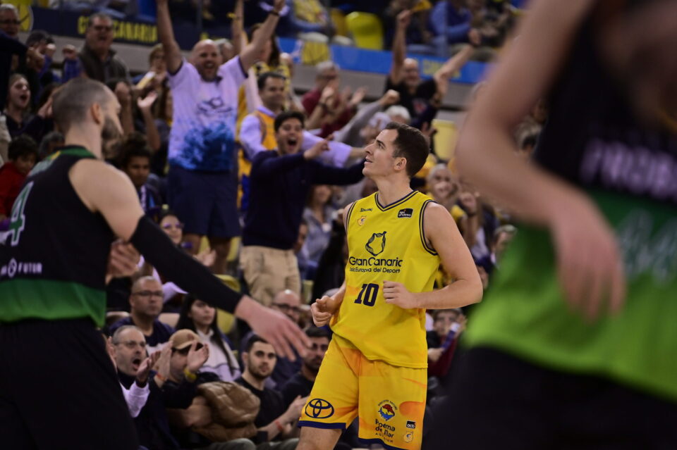 a por el penúltimo paso en el camino hacia la gloria europea",Jugador del Gran Canaria celebra mientras la afición vitorea en un emocionante partido.