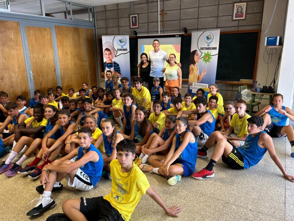Grupo de jóvenes en el XLII Campus de Verano CaixaBank, con carteles de actividades.