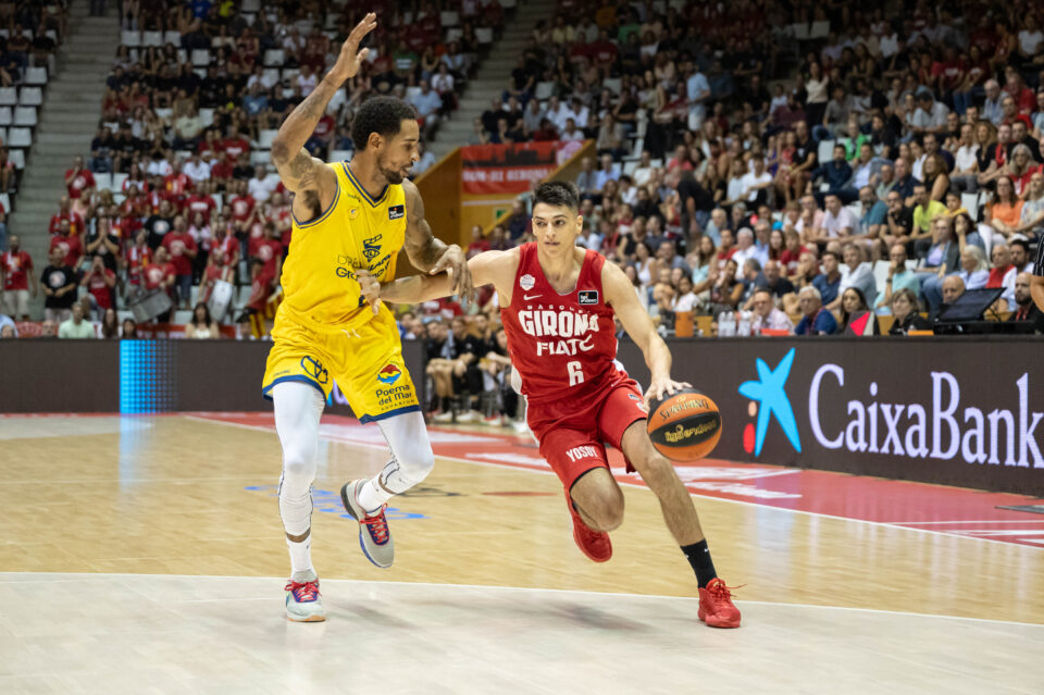 Jugador del Girona con balón driblando, mientras un rival del Gran Canaria lo defiende.