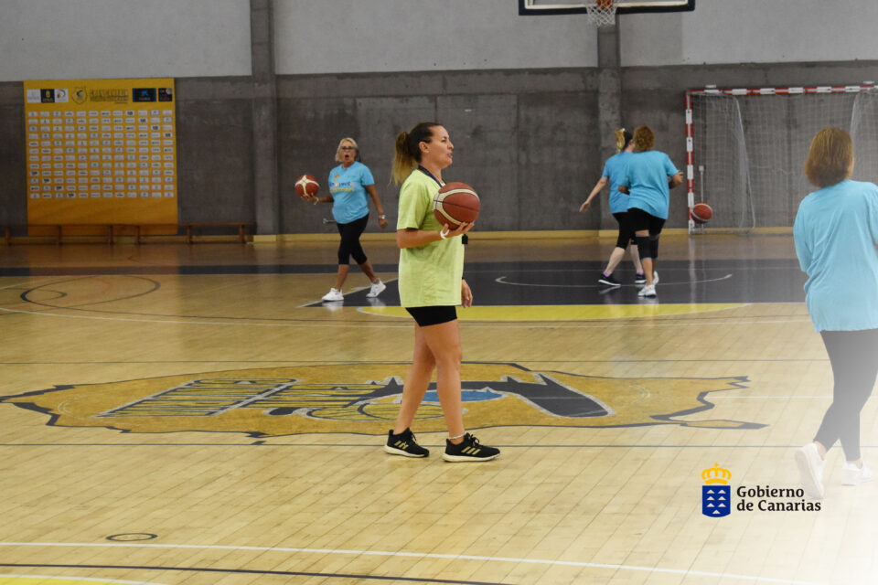 Mujeres entrenando en una cancha de baloncesto, promoviendo el Día Mundial Contra el Cáncer de Mama.