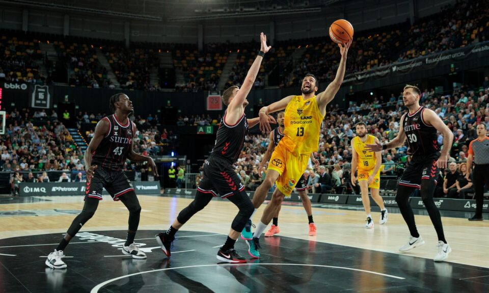 Jugador del Gran Canaria en acción durante un partido contra el Bilbao, con defensa adversaria.