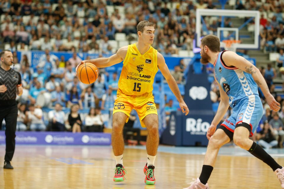 Jugador del Dreamland Gran Canaria driblando el balón en un partido de baloncesto.